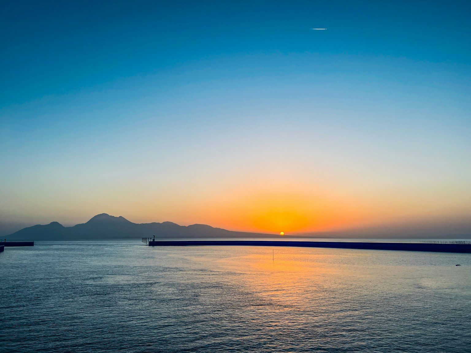 Bellissimo tramonto sul mare con montagne sullo sfondo