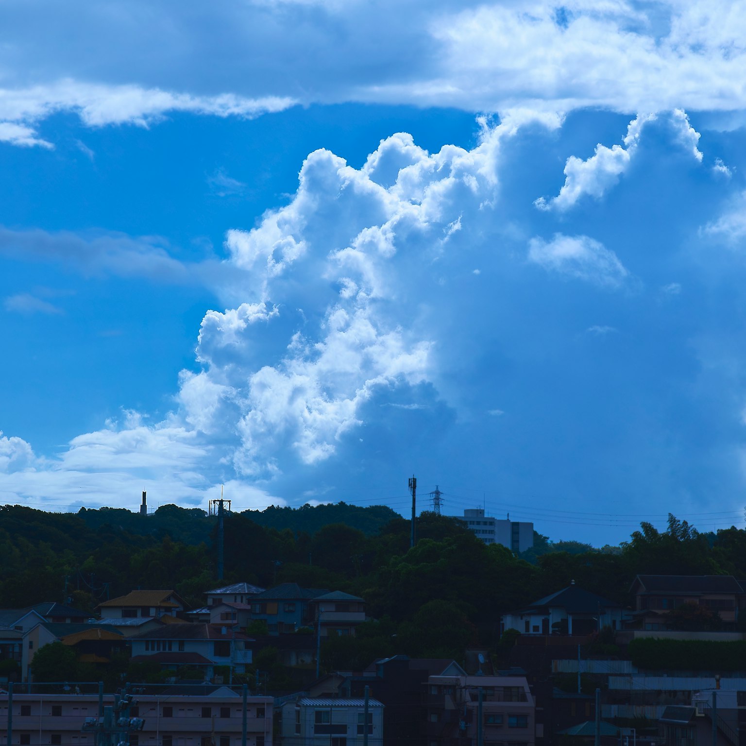 Grandi nuvole bianche su un cielo blu sopra un paesaggio collinare