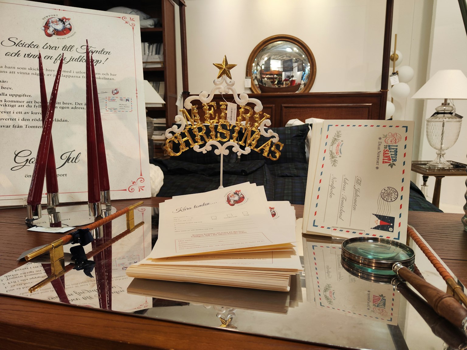 Eine Sammlung von Schreibwaren und Briefen auf einem Schreibtisch mit einem dekorativen Weihnachtsornament im Hintergrund