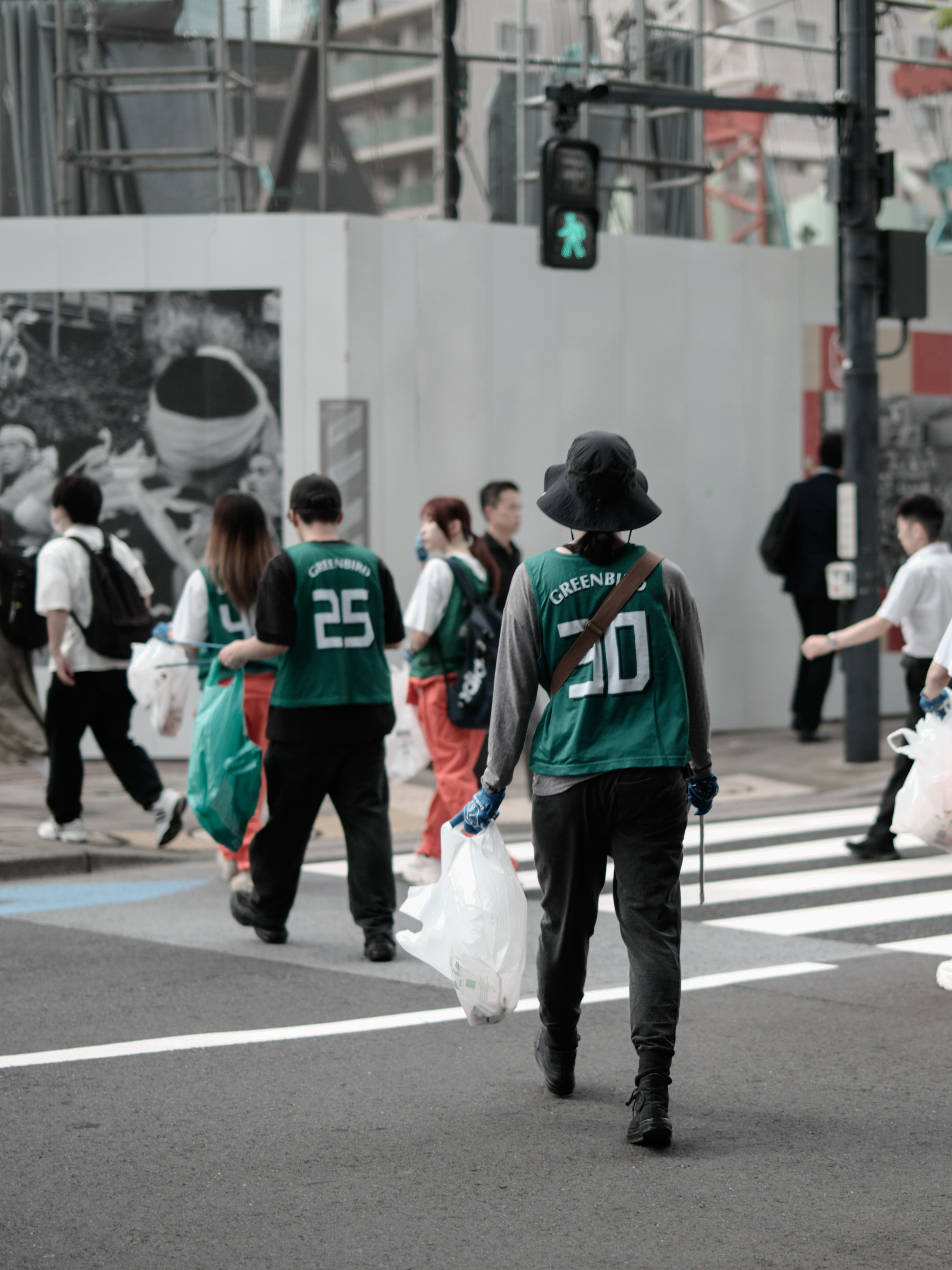 横断歩道を歩く人々と買い物袋のある街の風景