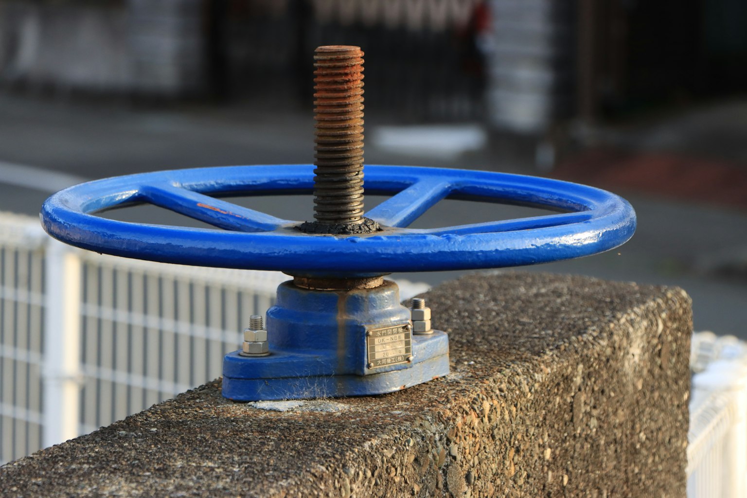 Rueda de válvula azul sobre una superficie de concreto