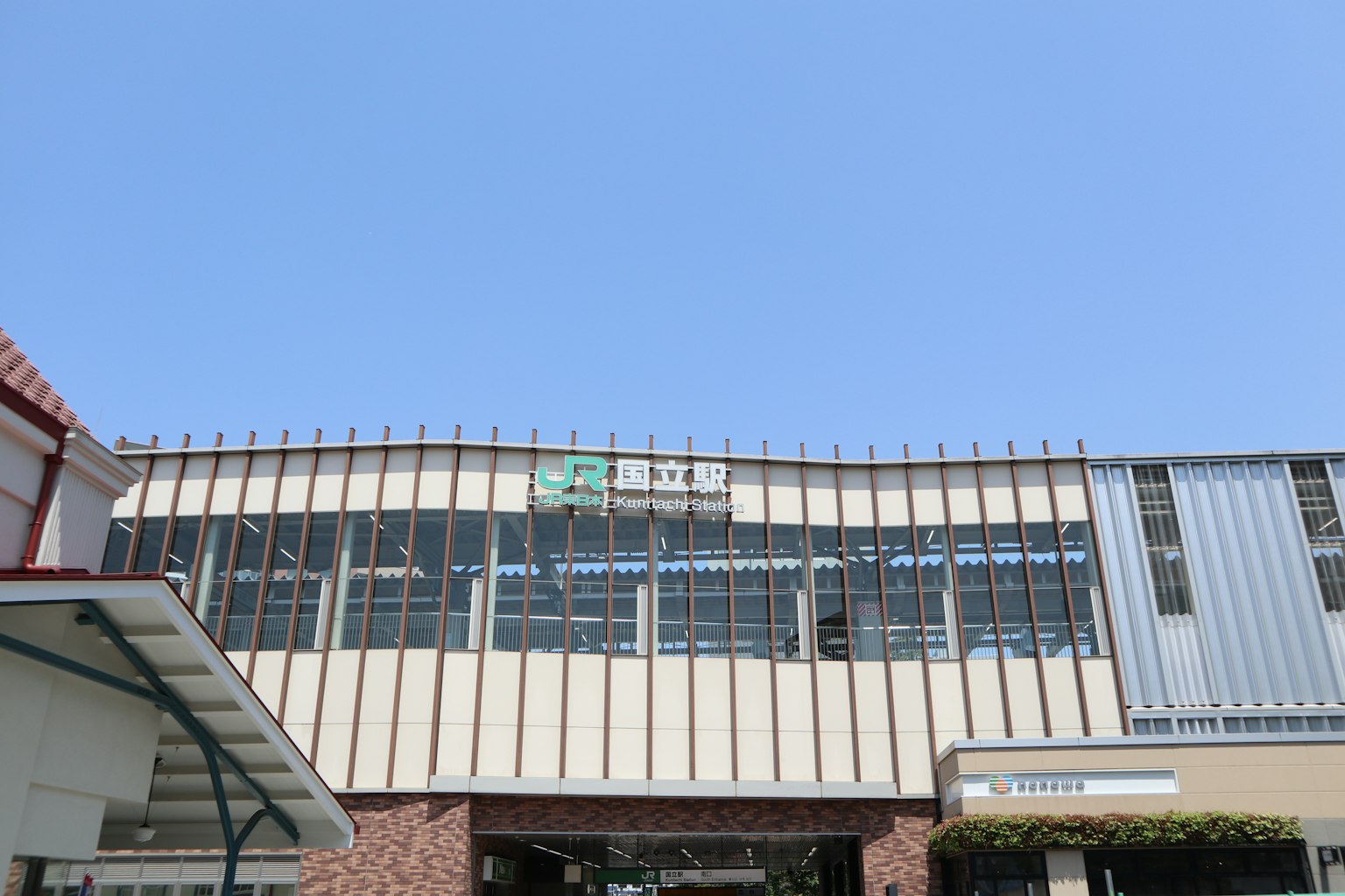 Exterior view of a factory under a blue sky with visible factory name