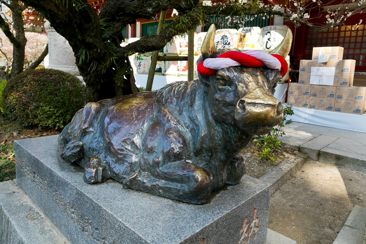 Una statua di bronzo di un toro sdraiato con un cappello rosso e bianco