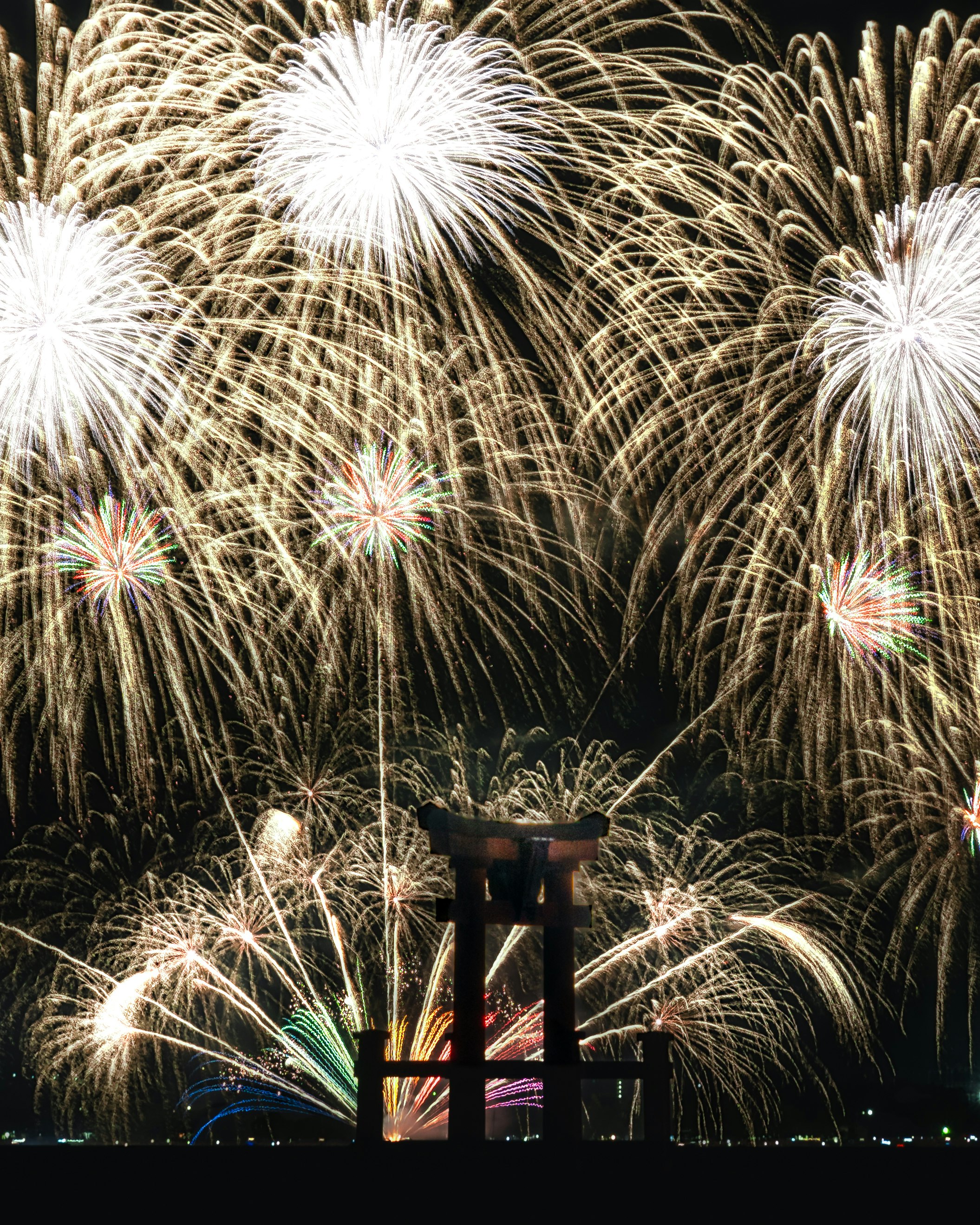 夜空に咲く花火と打ち上げ台のある花火大会の光景
