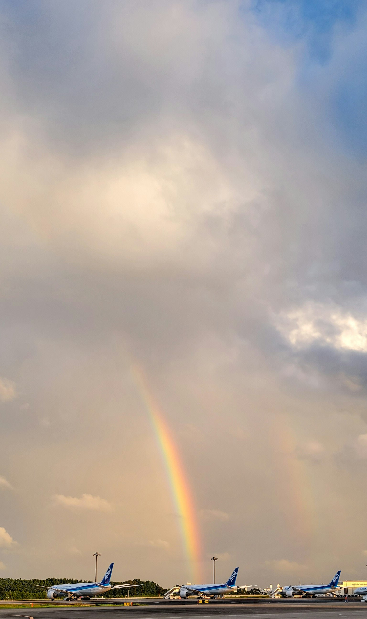 機場上方的彩虹與飛機的輪廓