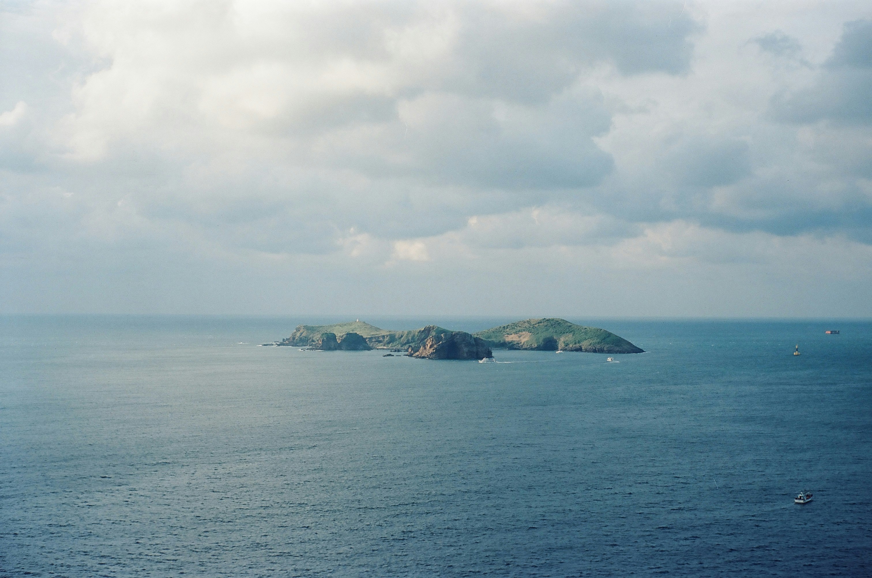 vista ampia dell’oceano con una piccola isola e barche al largo