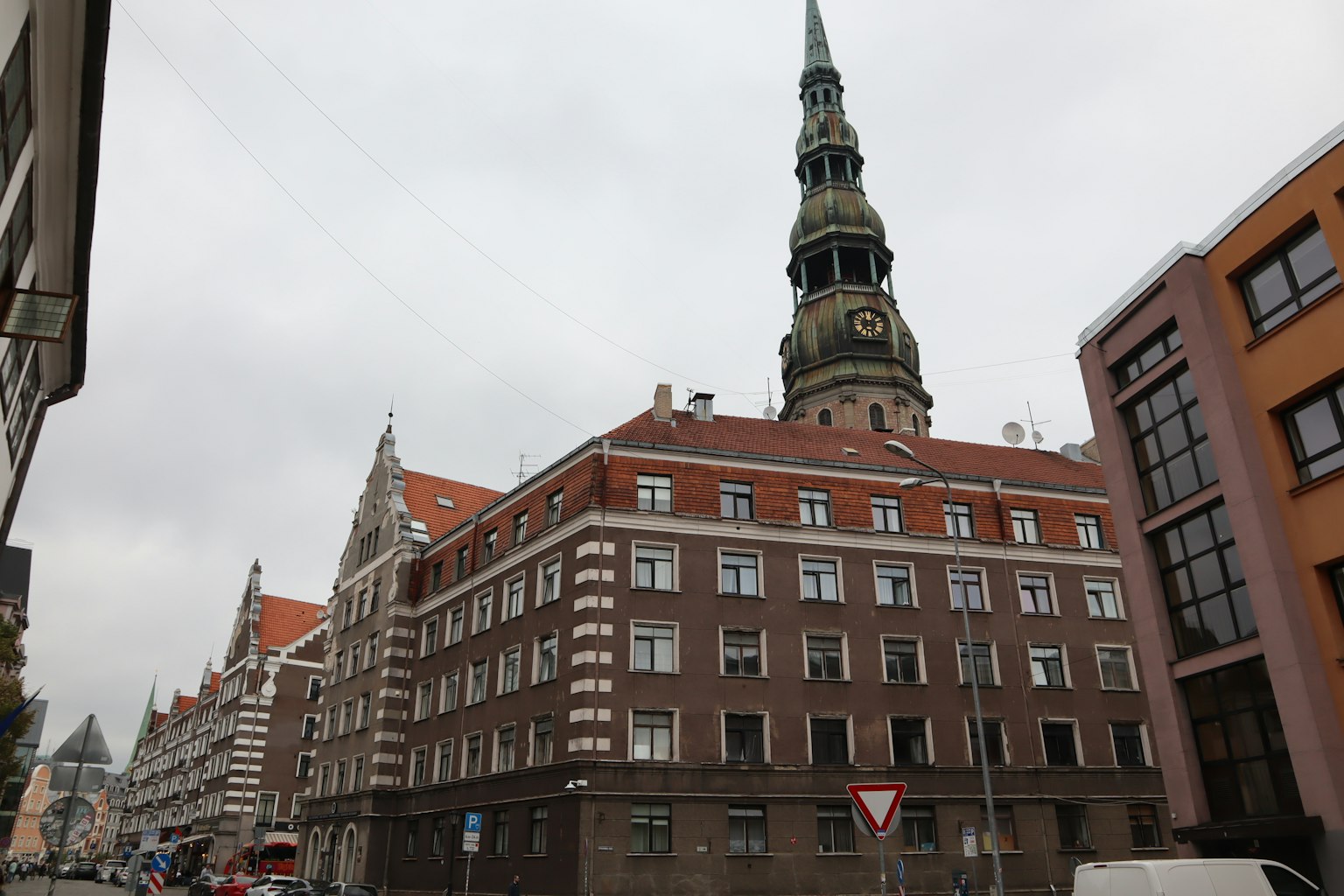 Vista de la calle que muestra un edificio antiguo con una torre distintiva junto a la arquitectura moderna