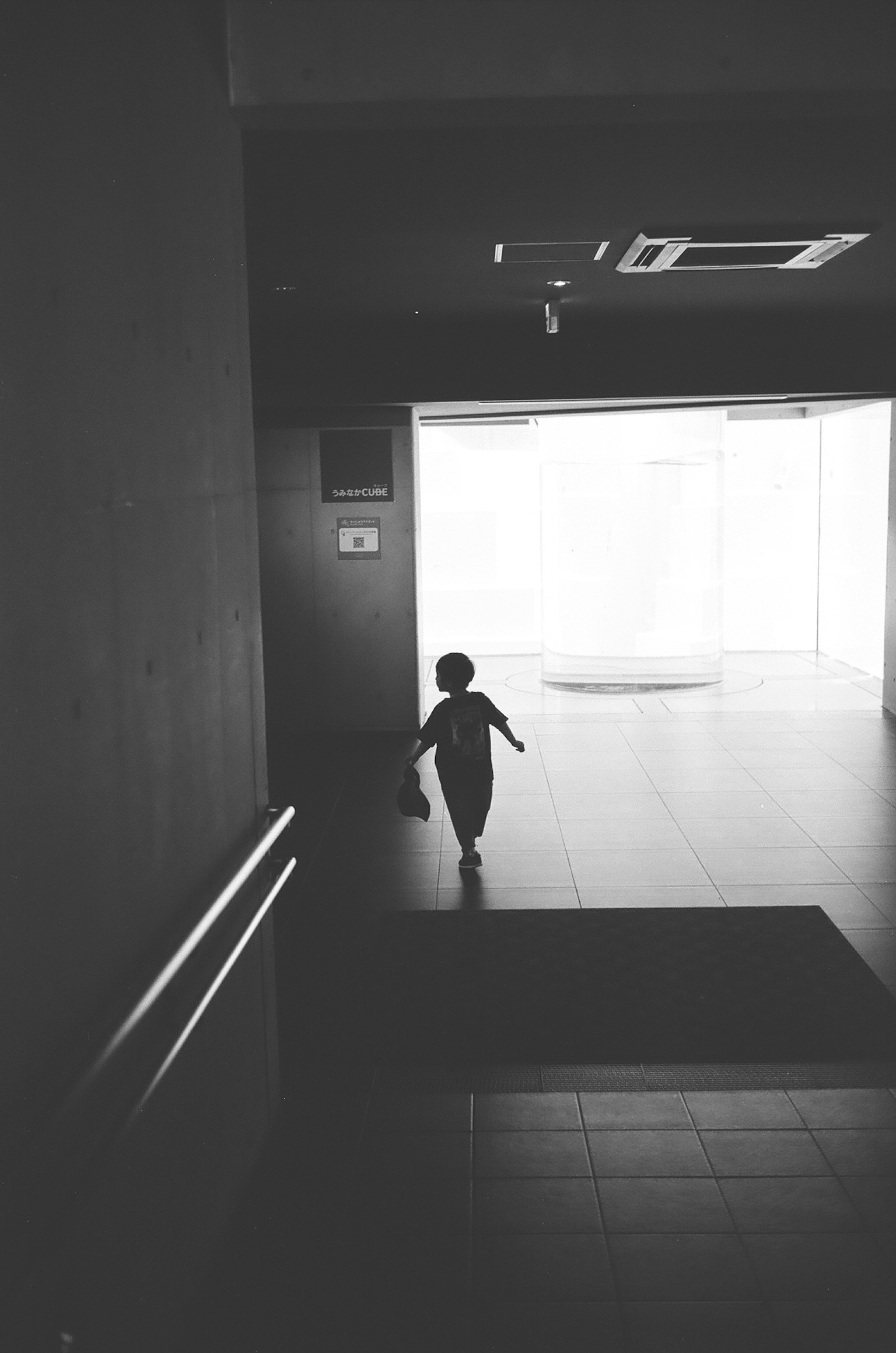 Bóng dáng của một đứa trẻ chạy về phía ánh sáng rực rỡ trong hành lang hiện đại