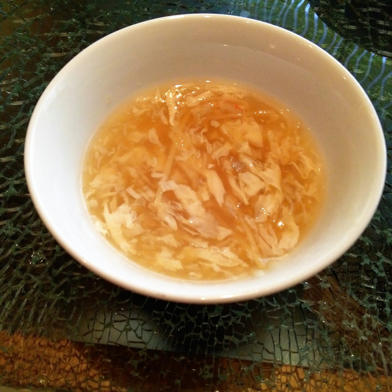 ซุปใสกับไก่ฉีกในชามสีขาว