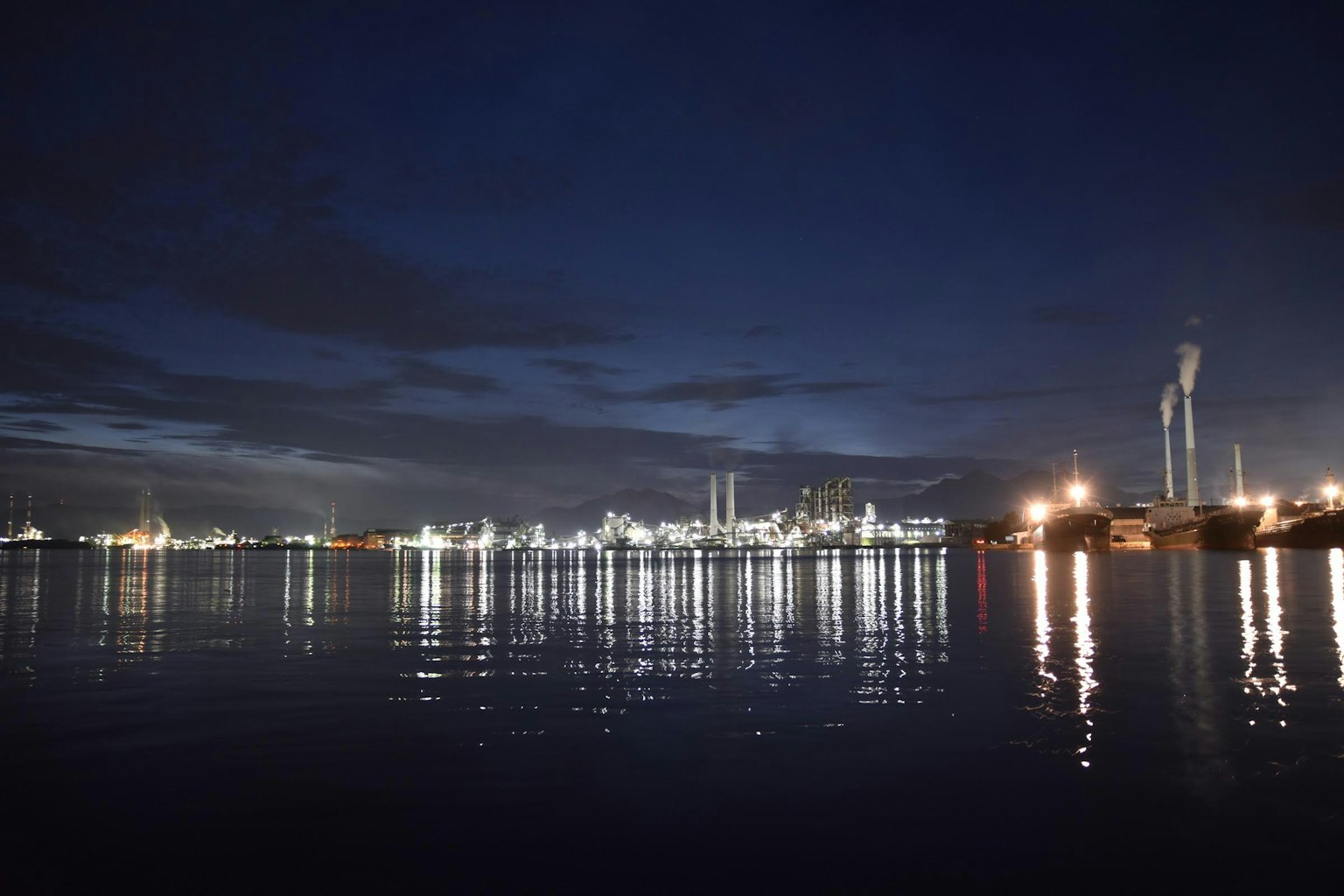 Nächtlicher Industriebereich mit Reflexionen im Wasser