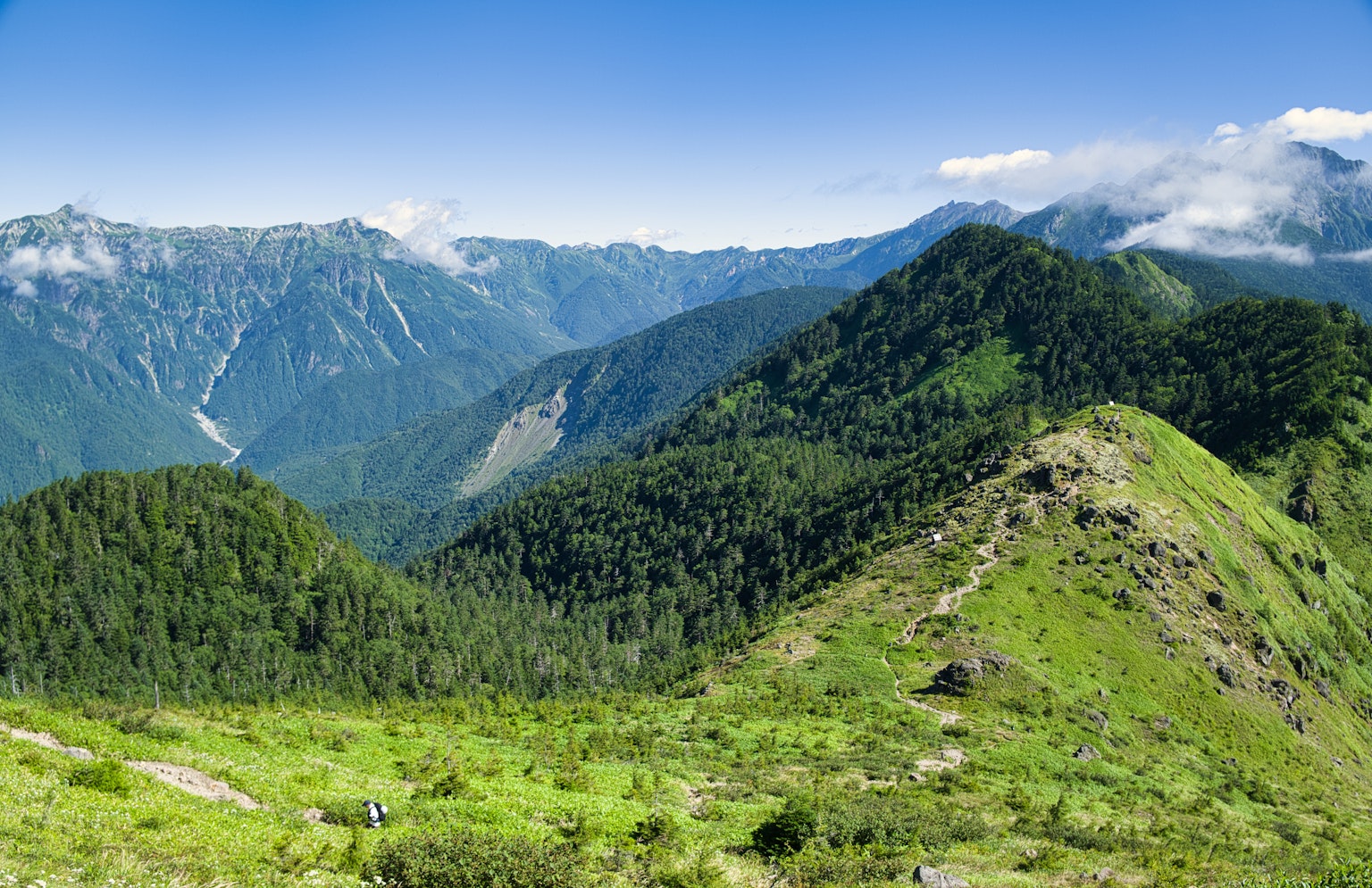 Montagnes verdoyantes sous un ciel bleu clair
