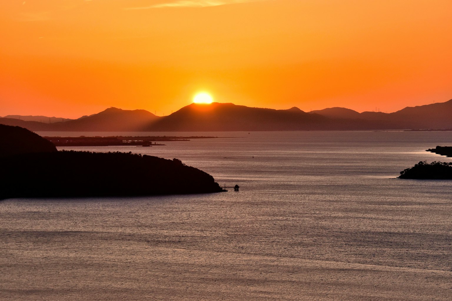 Bellissimo paesaggio del mare e delle montagne al tramonto