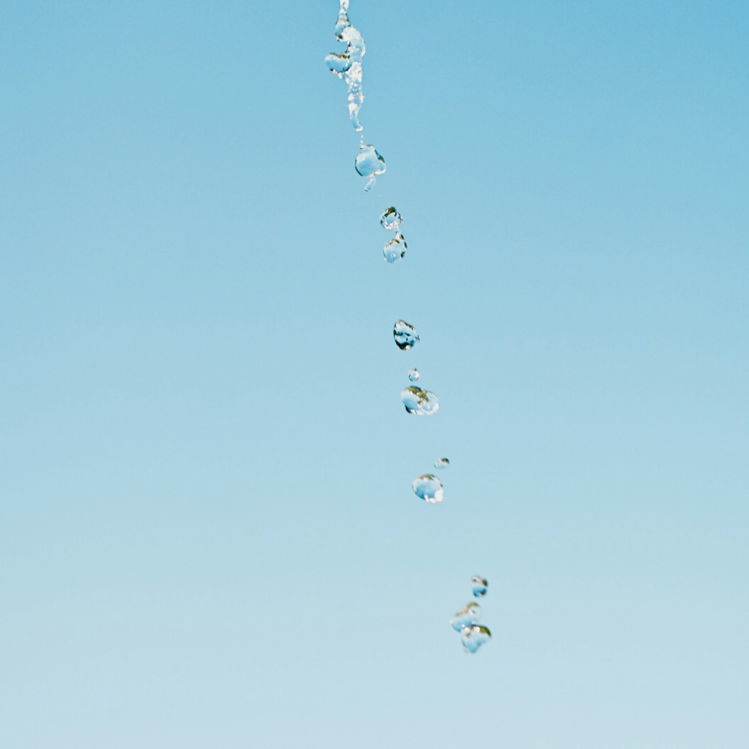 水滴在清澈蓝天下落