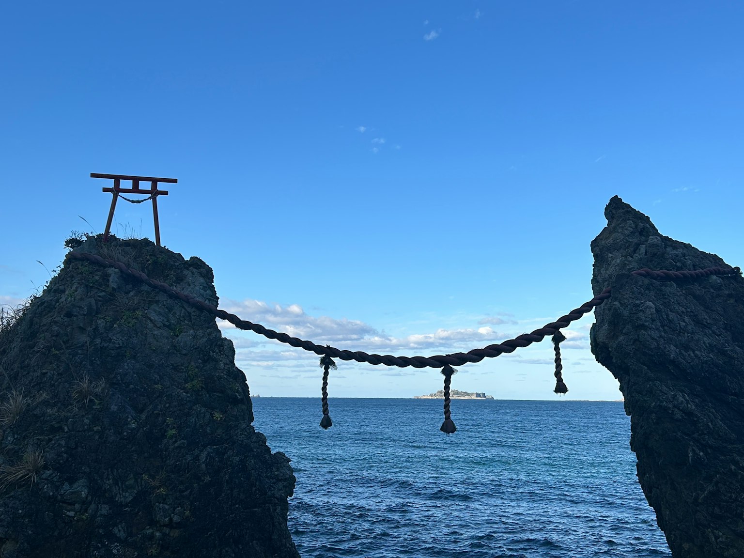 Torii e ponte in catena tra rocce sul mare