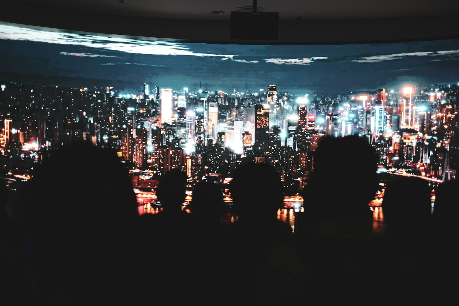 夜景を楽しむ人々のシルエットと都市の明るい光