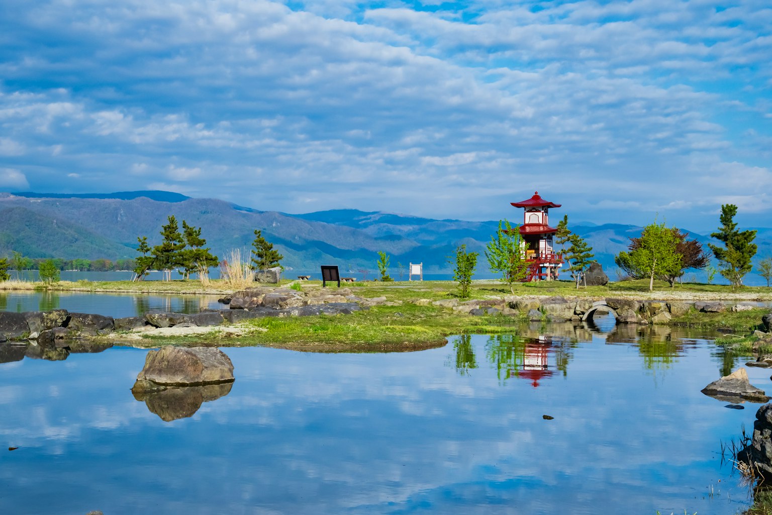 Vista escénica de un estanque que refleja un pabellón rojo