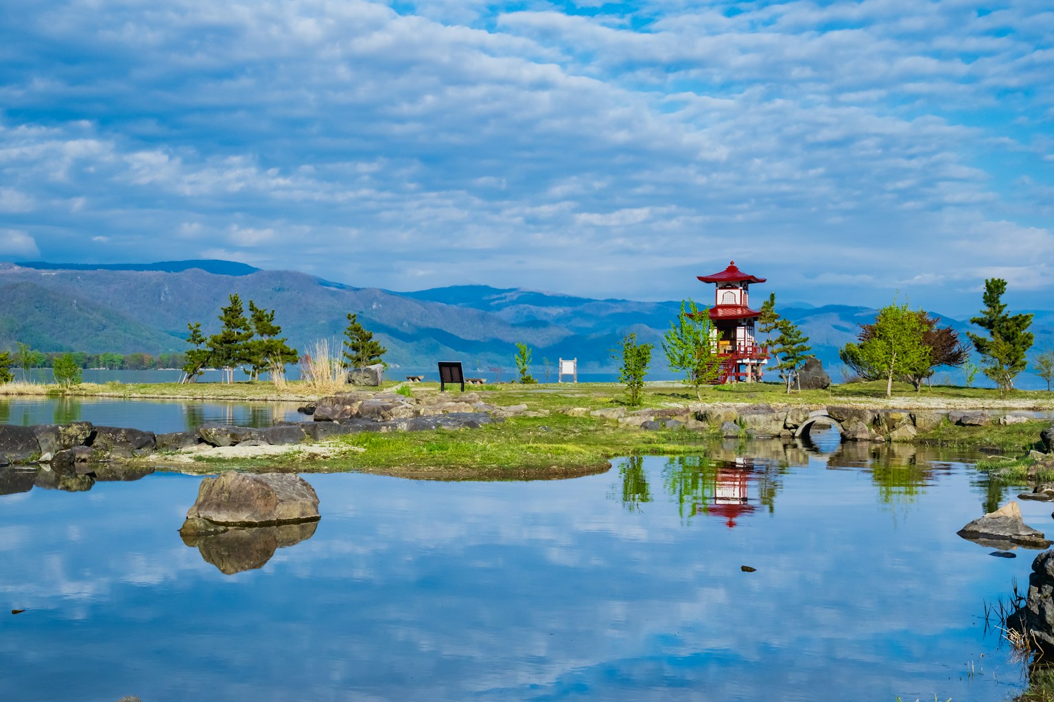 Scenic view of a pond reflecting a red pavilion