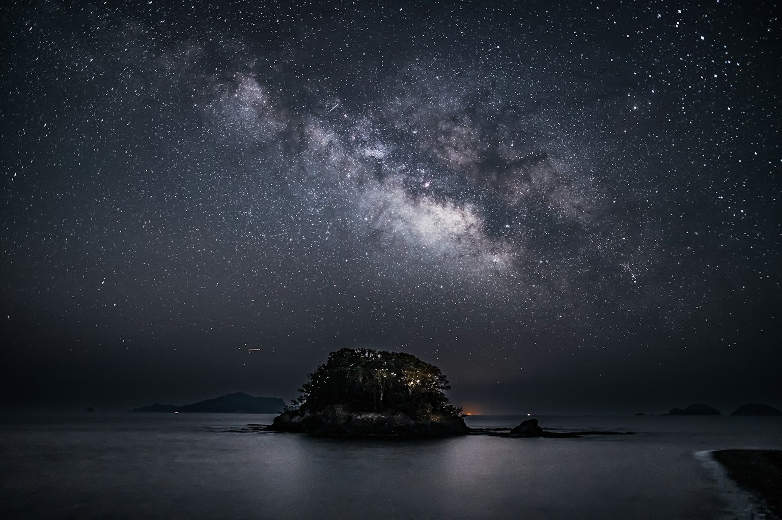 Un'isola serena sotto un cielo stellato con una vista mozzafiato della Via Lattea