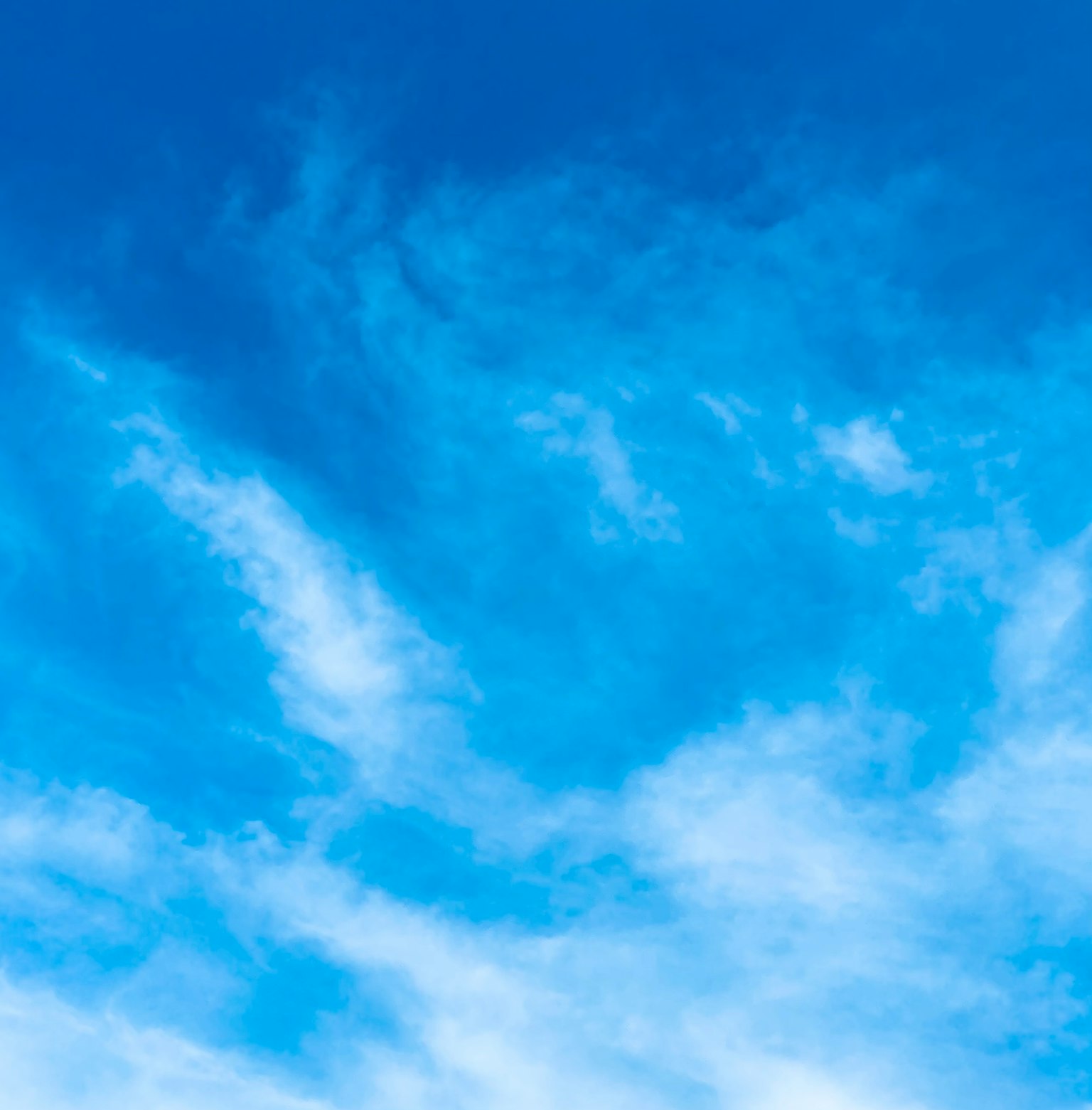 Ciel bleu vibrant avec des nuages blancs filants