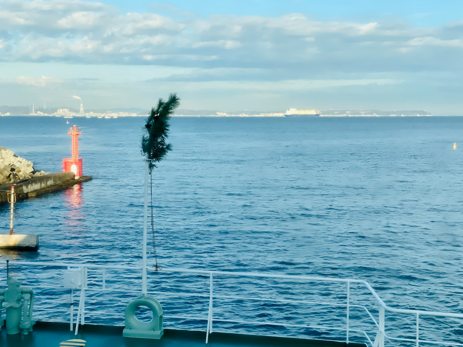Vista panoramica dell'oceano blu e del cielo con un faro rosso nel porto