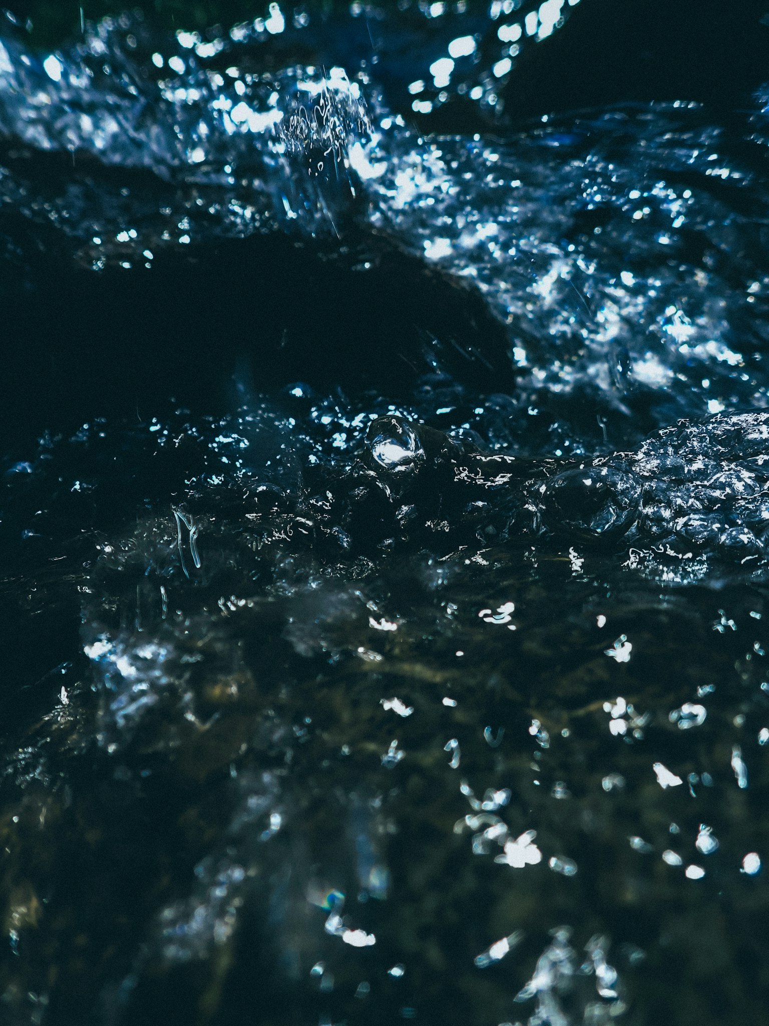 Funkelndes Licht auf der Wasseroberfläche mit fließendem dunklem Wasser