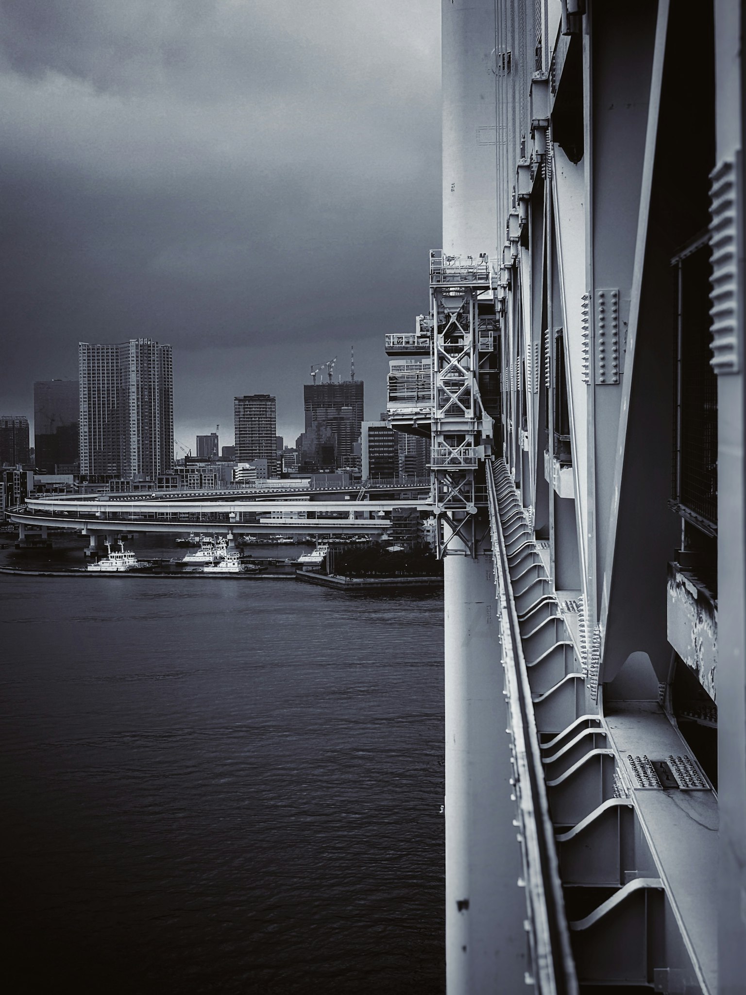 Horizonte urbano bajo nubes oscuras con estructura de puente