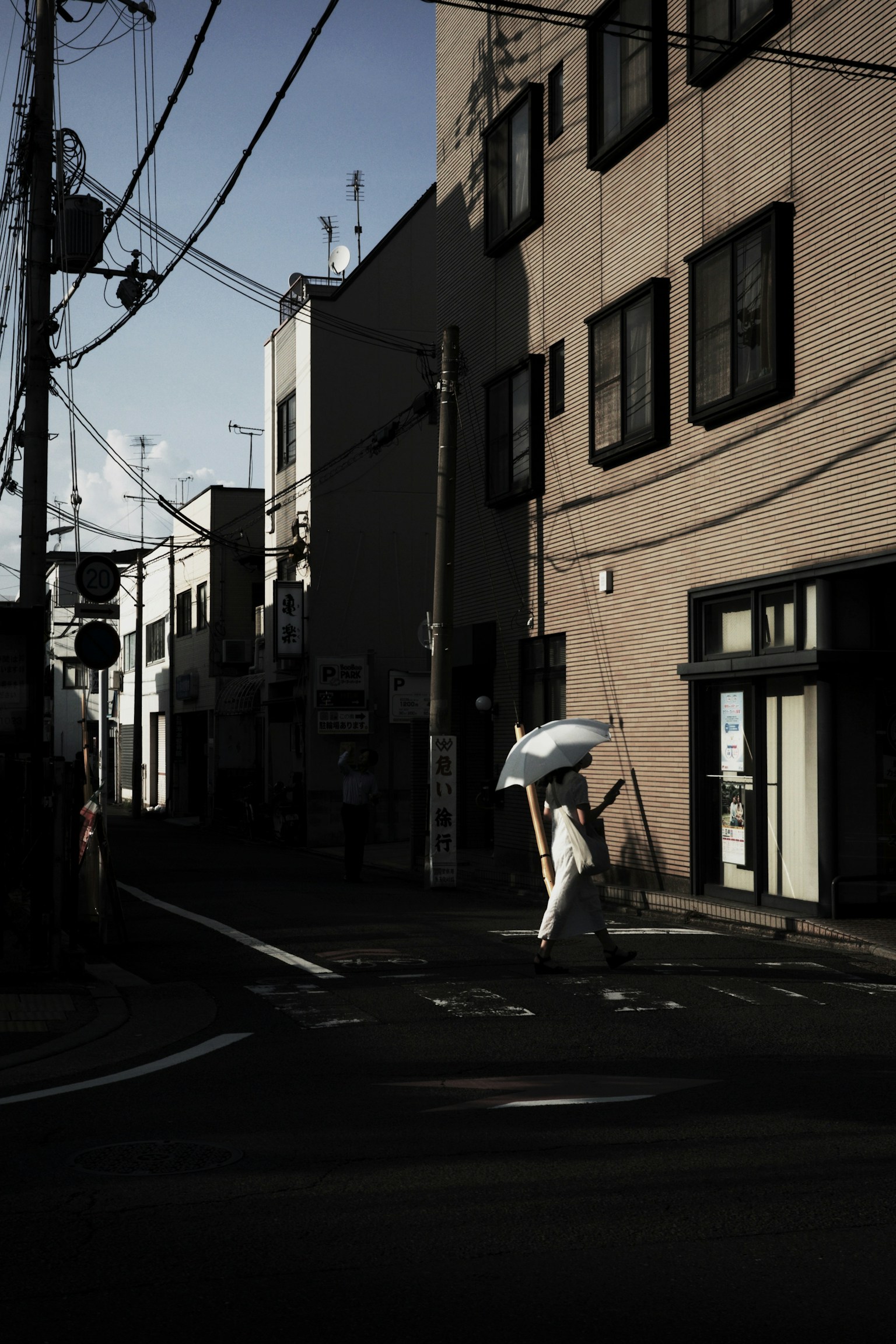 Seseorang berjalan di jalan gelap sambil memegang payung