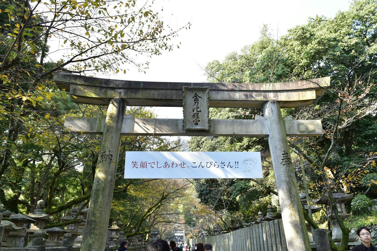 Cổng torii với biển hiệu và nền xanh tươi tốt