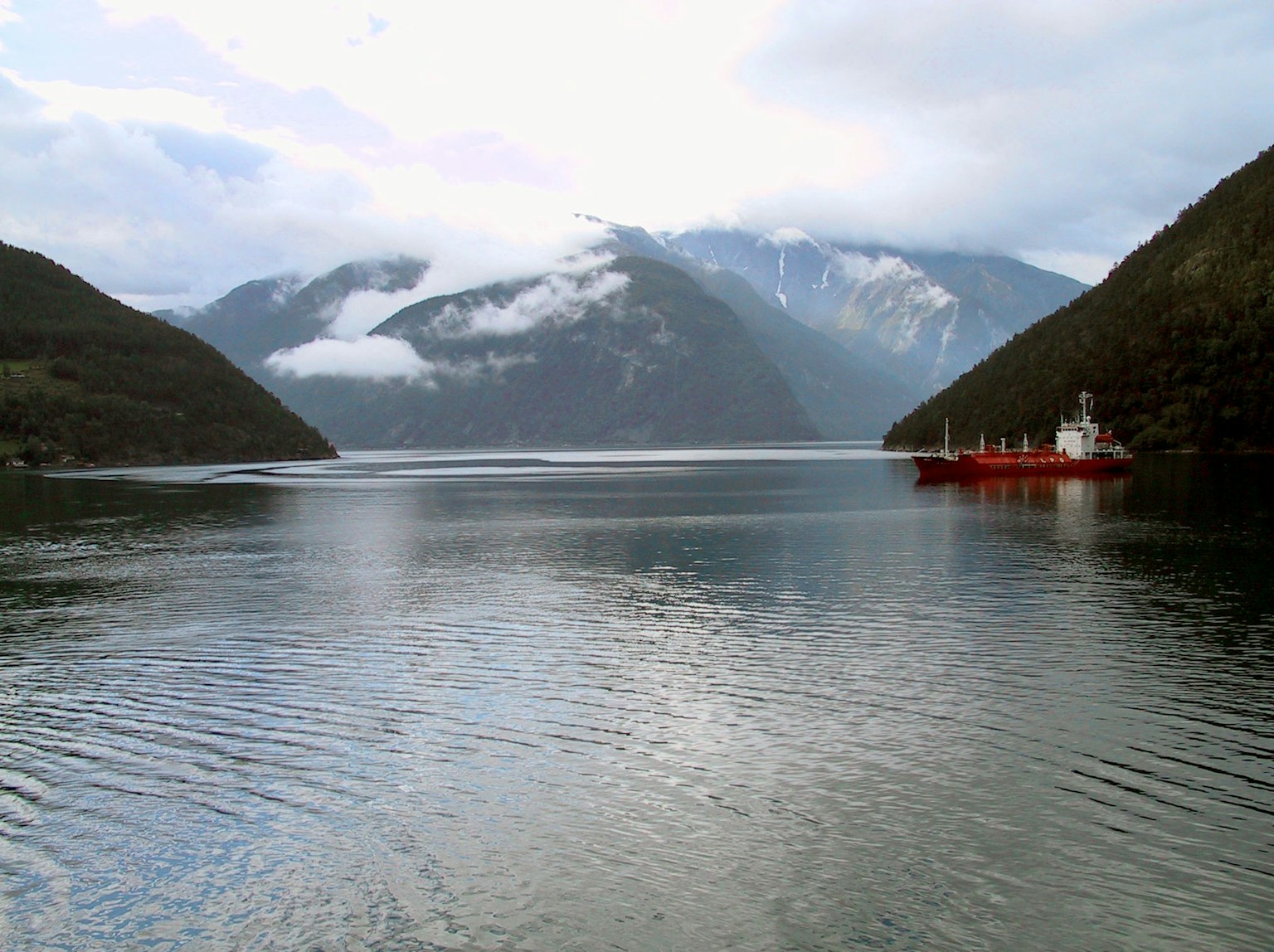 宁静的海湾，红色船只和山脉景观