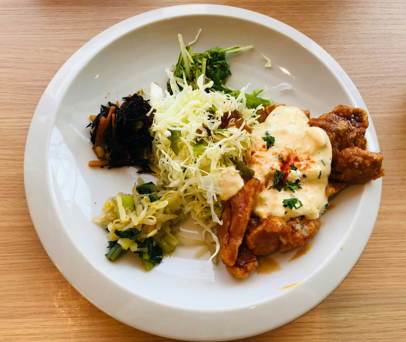 Japanisches Gericht auf einem weißen Teller mit gebratenem Hühnchen und Krautsalat