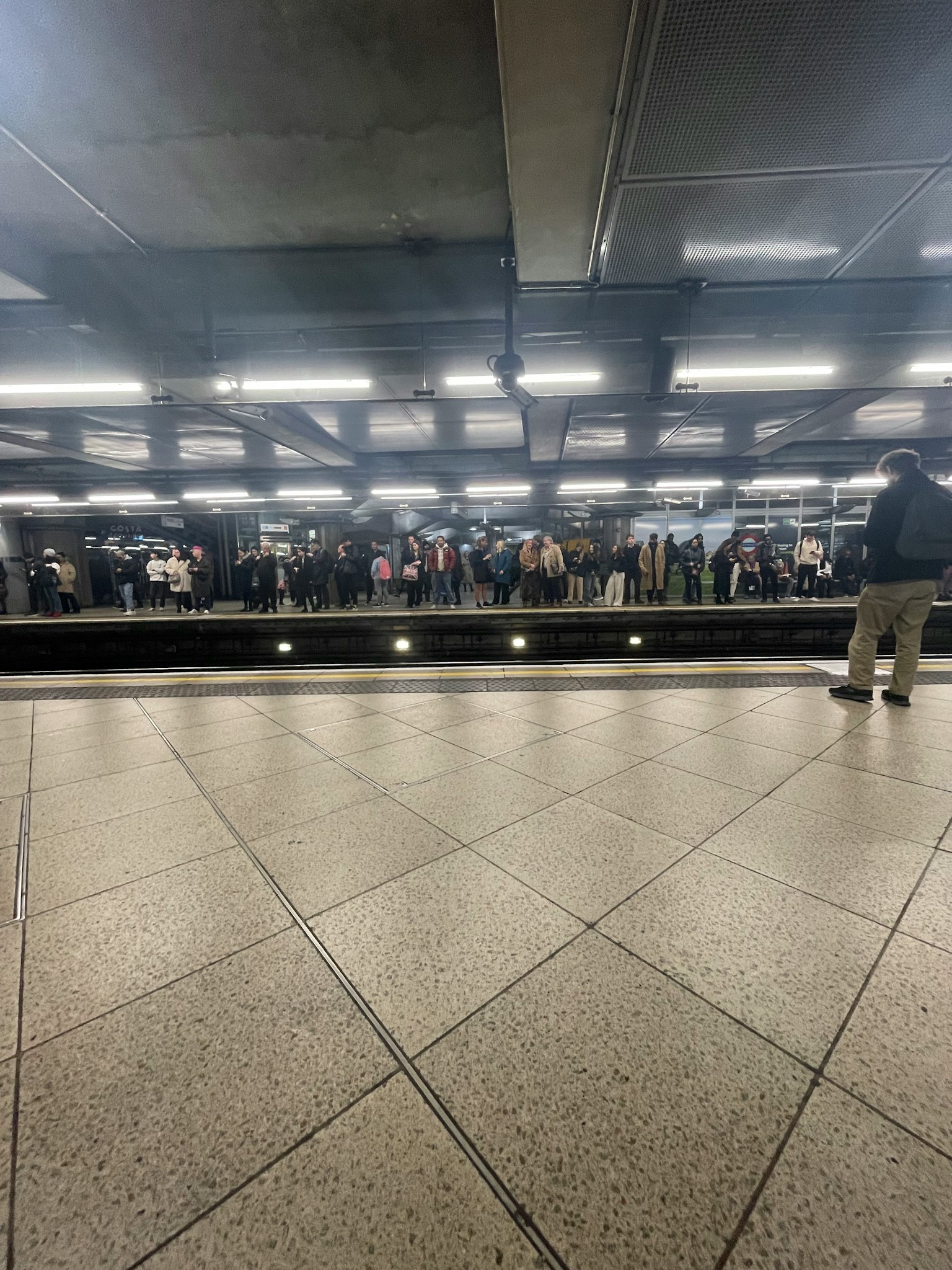 Menschenmenge auf einem U-Bahn-Bahnhof mit reflektierten Lichtern