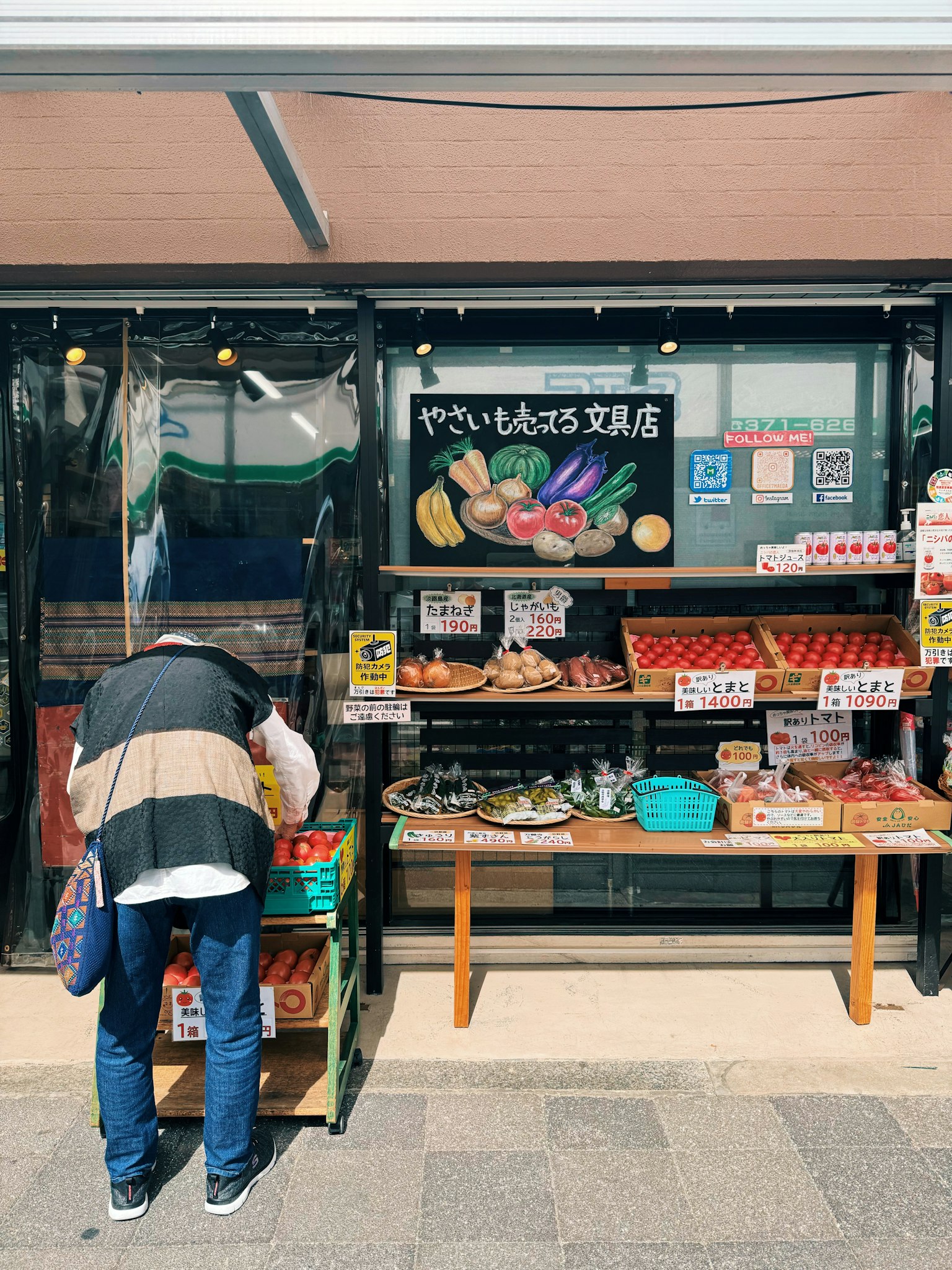 A woman shopping at a market stall displaying fresh vegetables and fruits