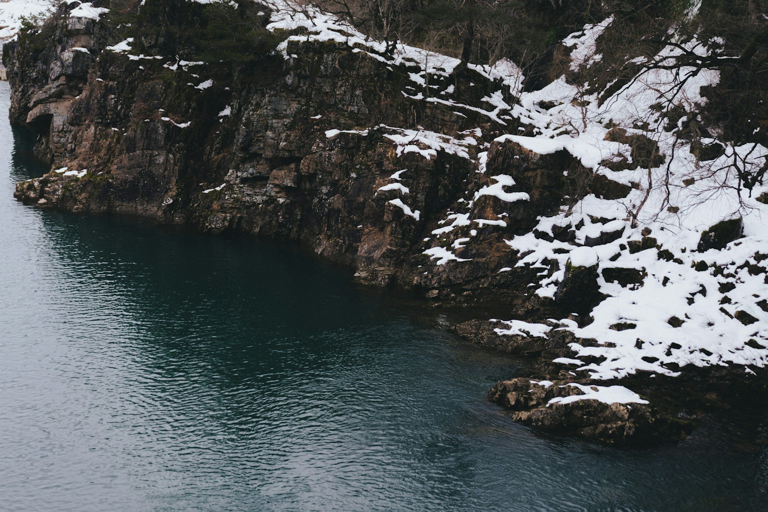 Rocas cubiertas de nieve con una superficie de agua tranquila