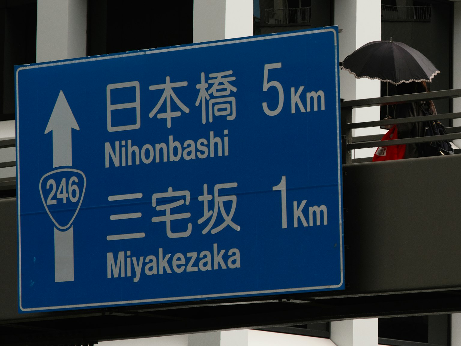 Biển báo đường màu xanh hiển thị khoảng cách đến Nihonbashi và Miyakezaka