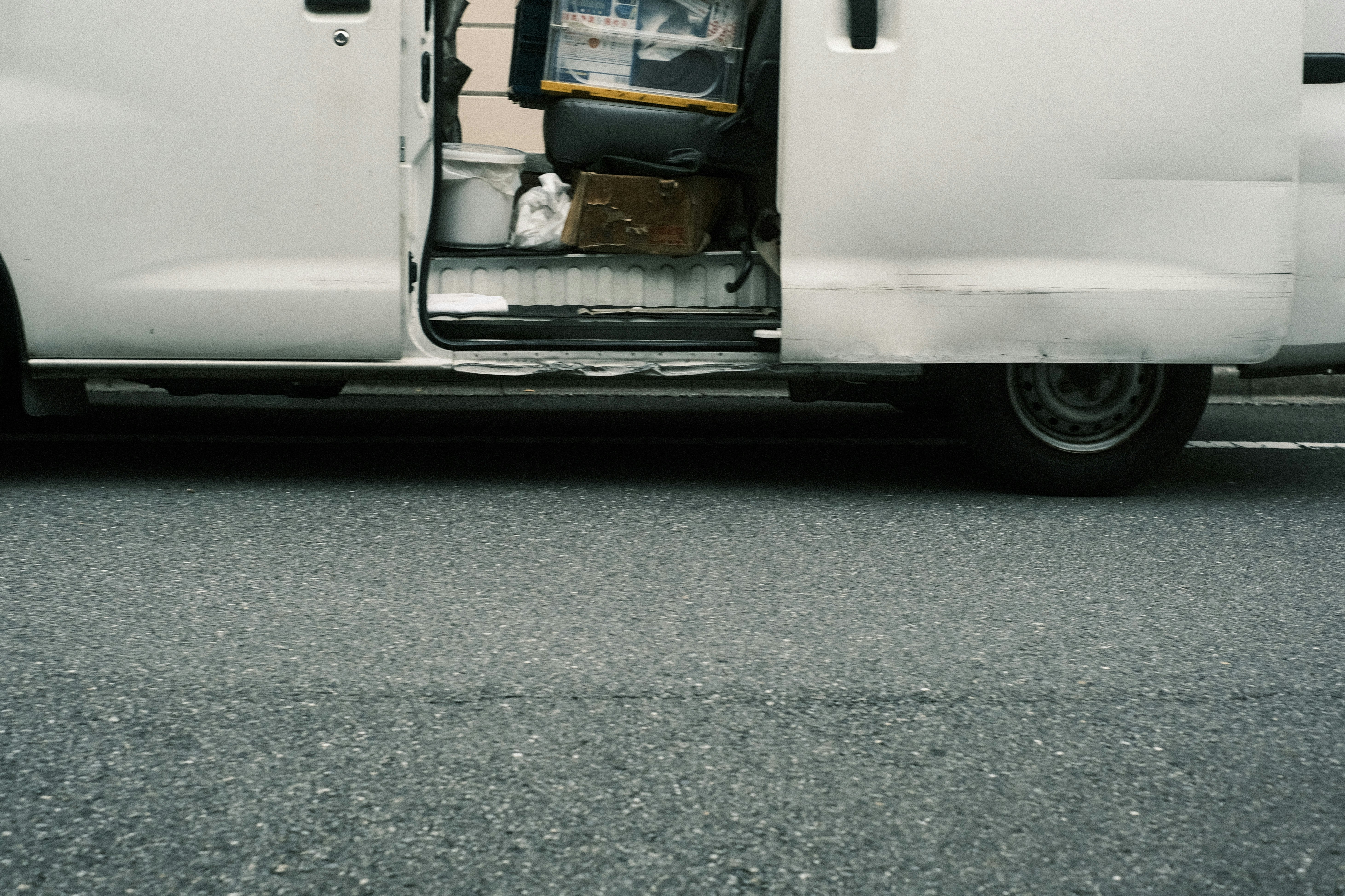 路上を走るバンの荷台が開いた瞬間