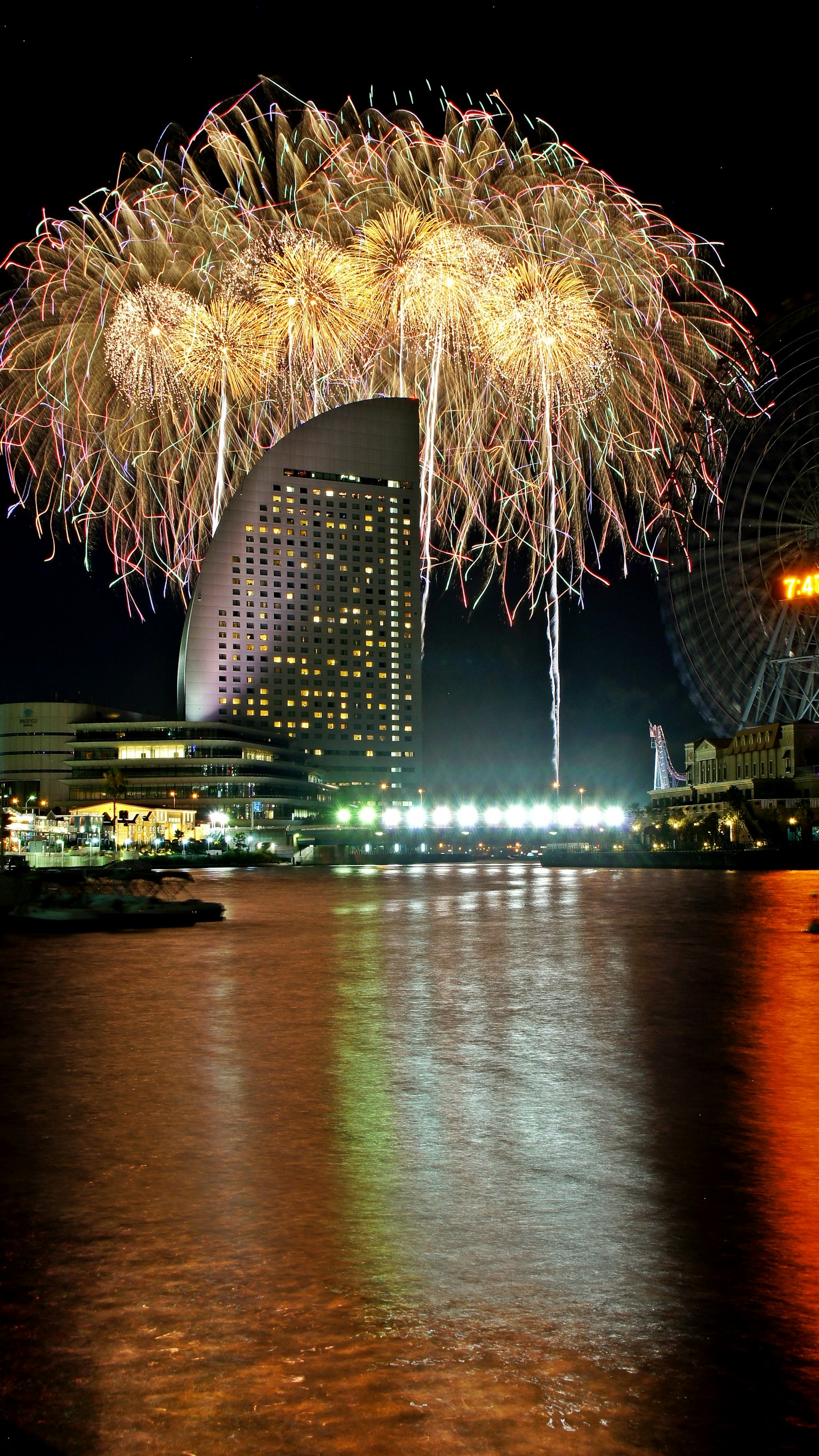Feuerwerk erhellt den Nachthimmel mit Reflexionen im Wasser