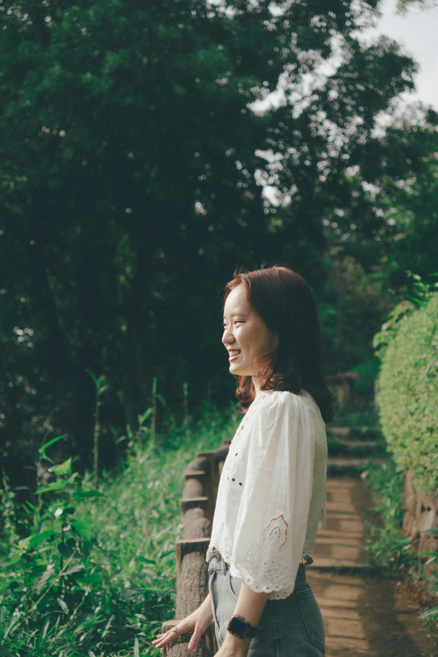 미소를 지으며 푸른 길을 걷는 여성