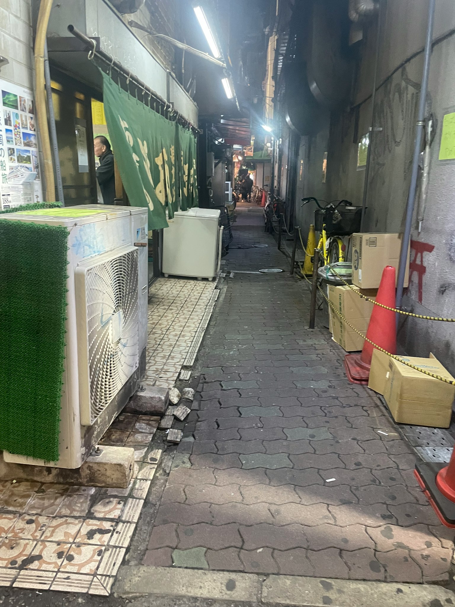 Schmale Gasse mit einer Klimaanlage und Kartons