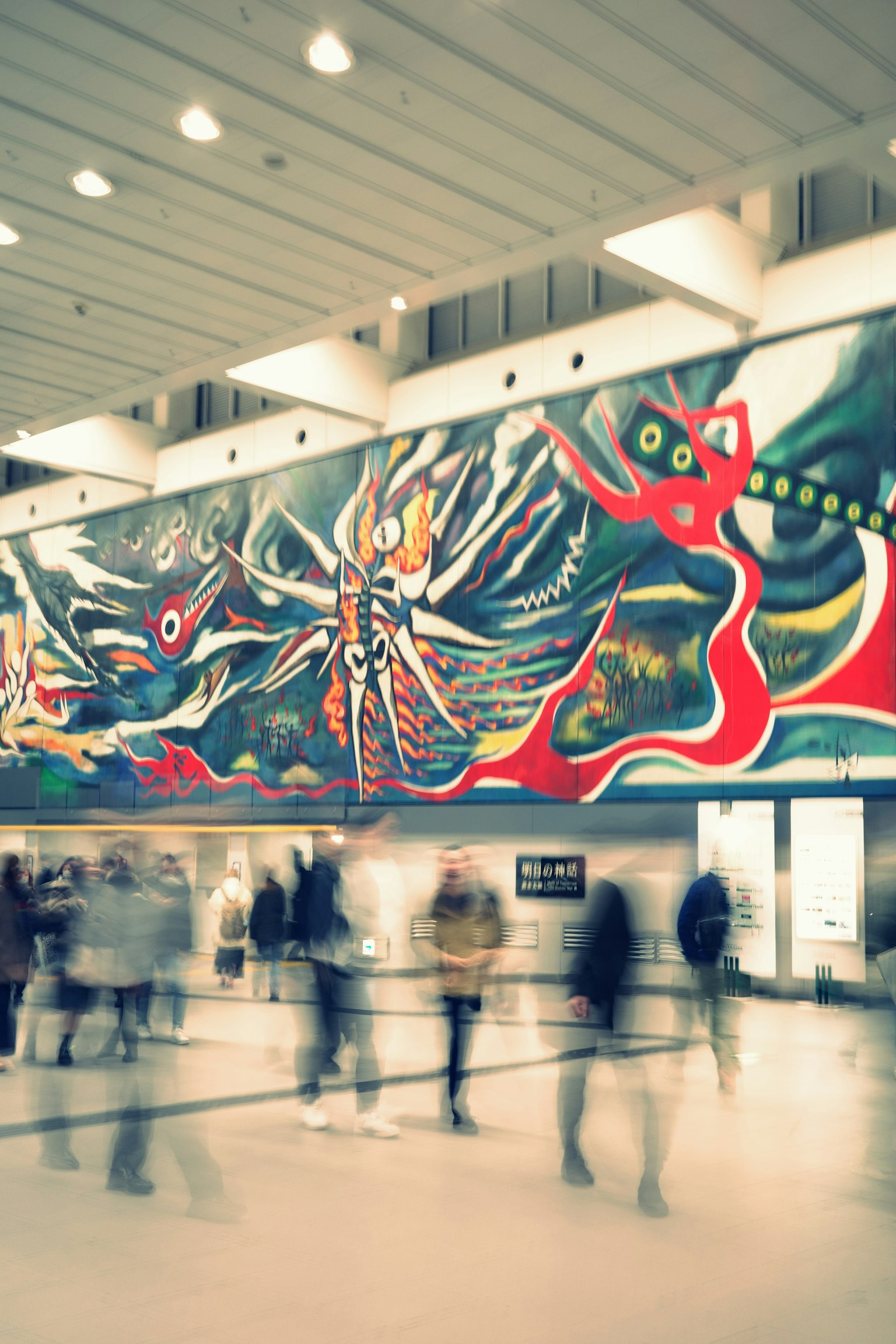 A vibrant mural with abstract designs and blurred figures of people walking