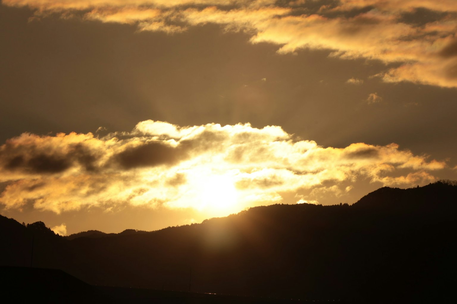 Tramonto dietro le nuvole sopra le montagne