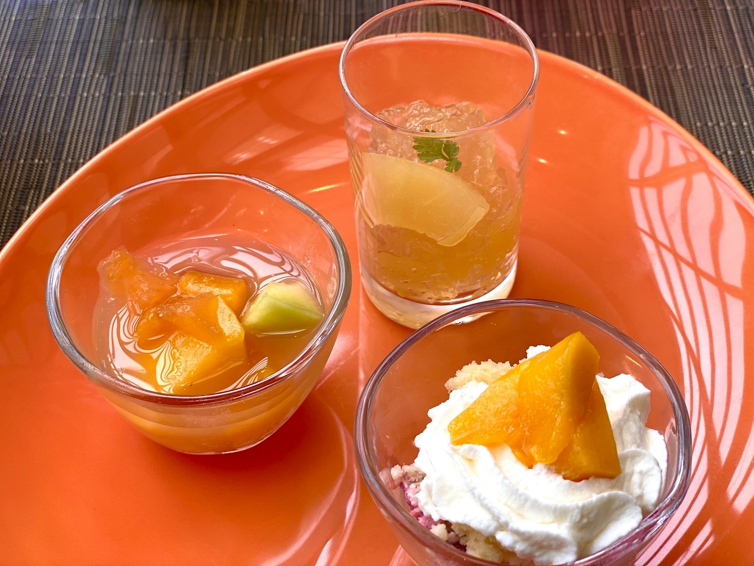 A set of fruit desserts served on an orange plate