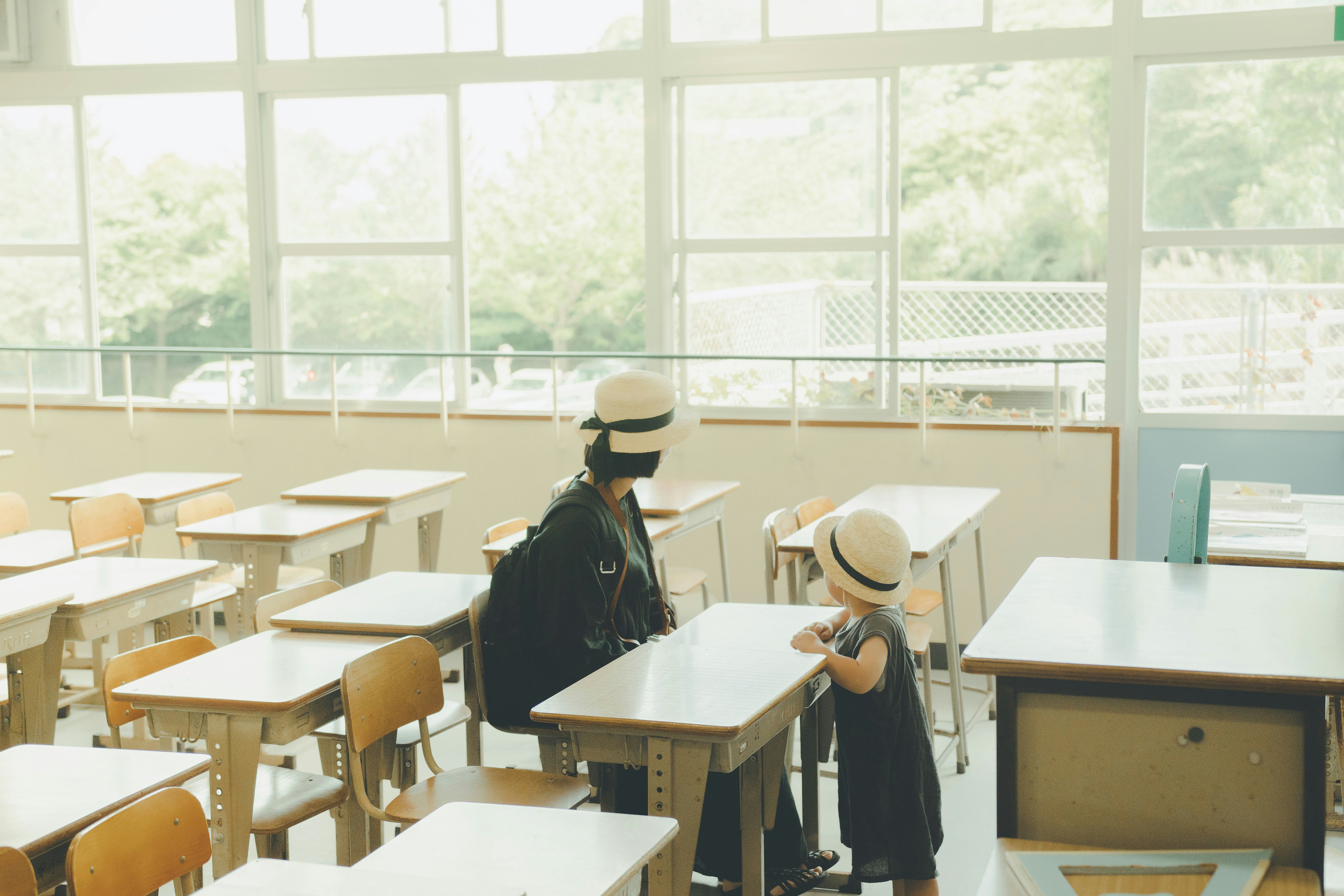 students at desks in a bright classroom with windows