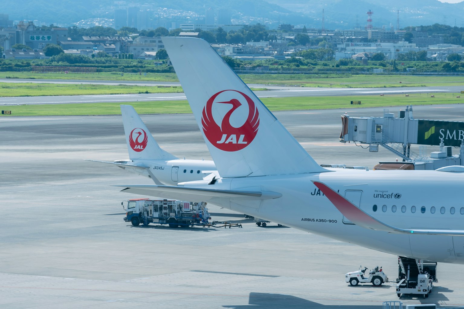 Tail of a Japan Airlines aircraft on the runway at an airport