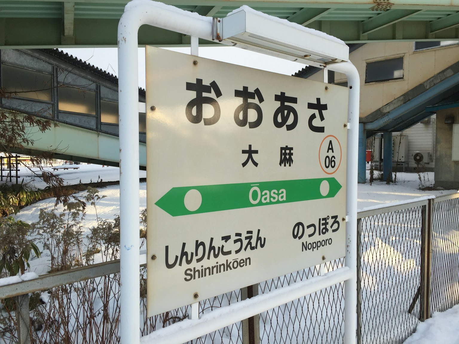Schild der Station Oasa mit schneebedeckter Umgebung