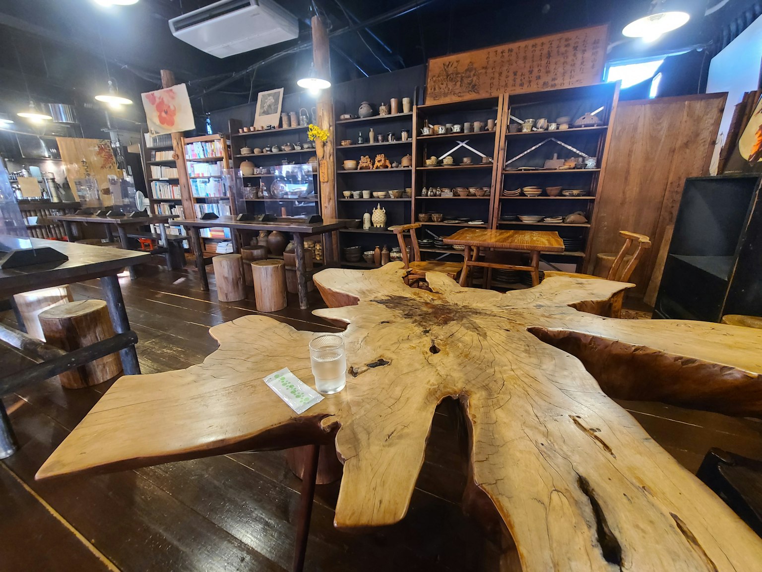 Interior de una tienda con una mesa de madera y estanterías