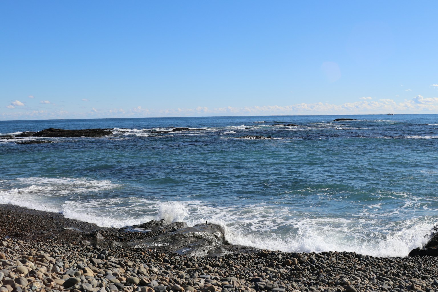 Vista escénica del océano azul con playa rocosa