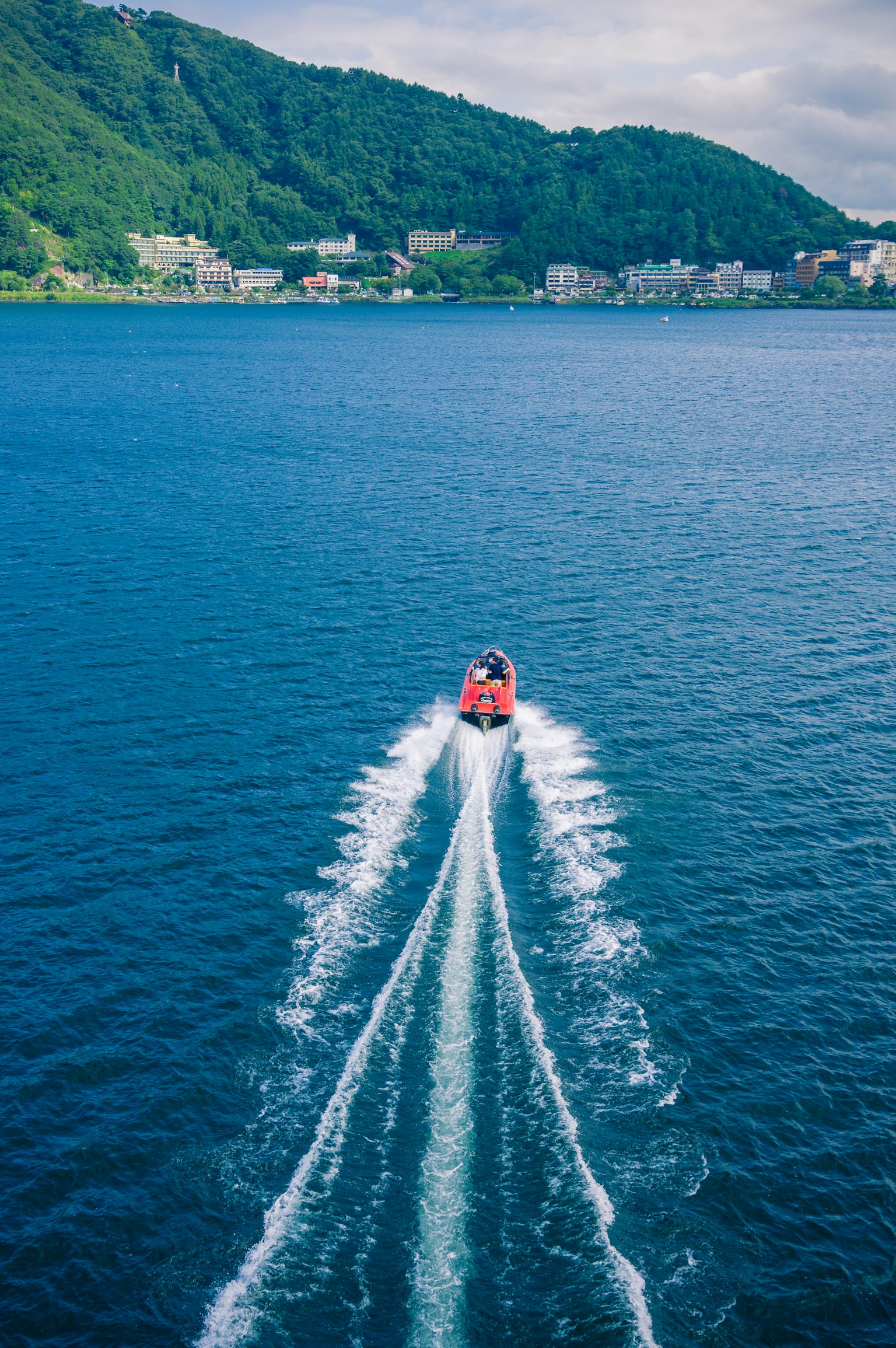 Vue aérienne d'un bateau rouge glissant sur l'eau bleue