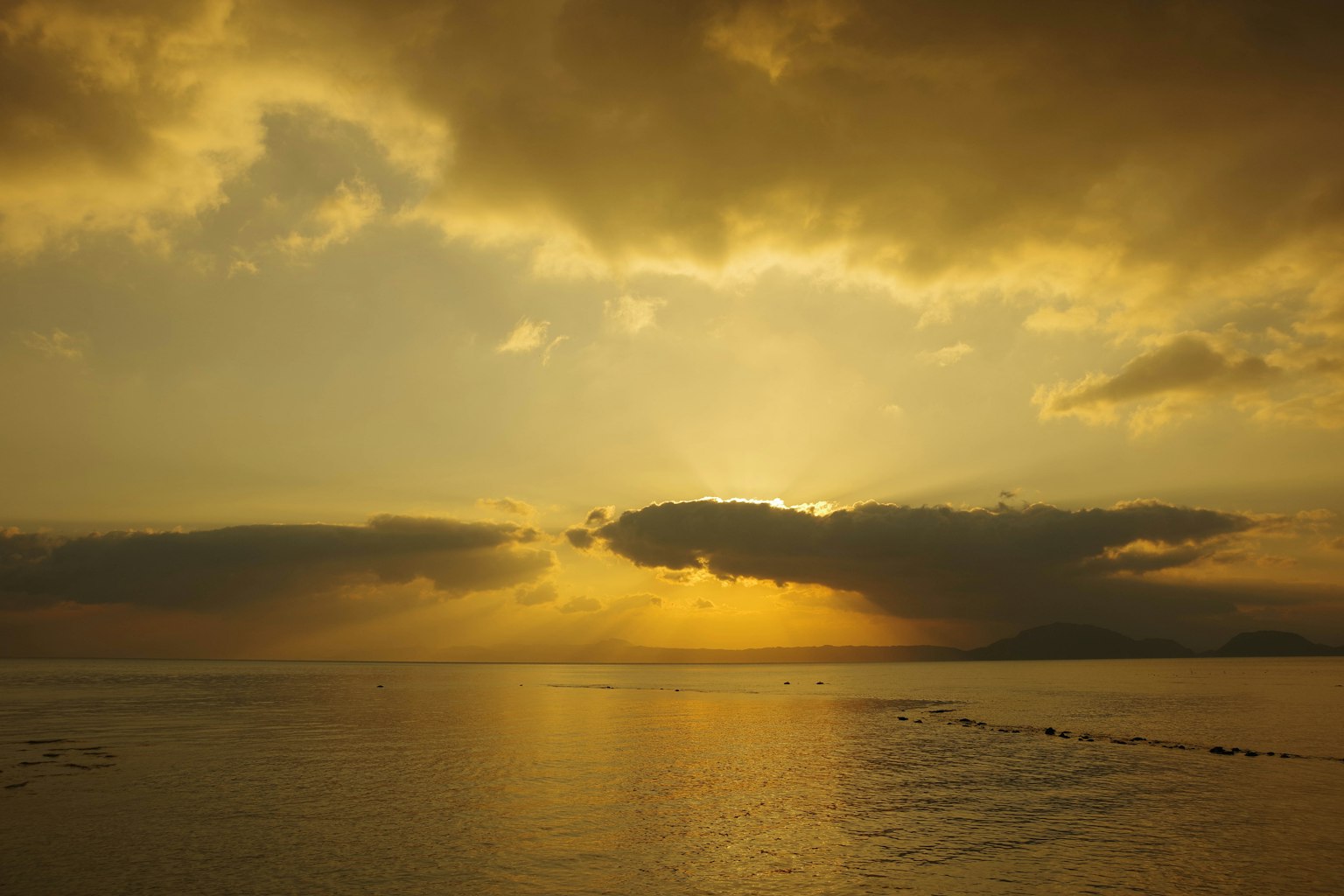 Beautiful seascape at sunset with clouds and golden sky
