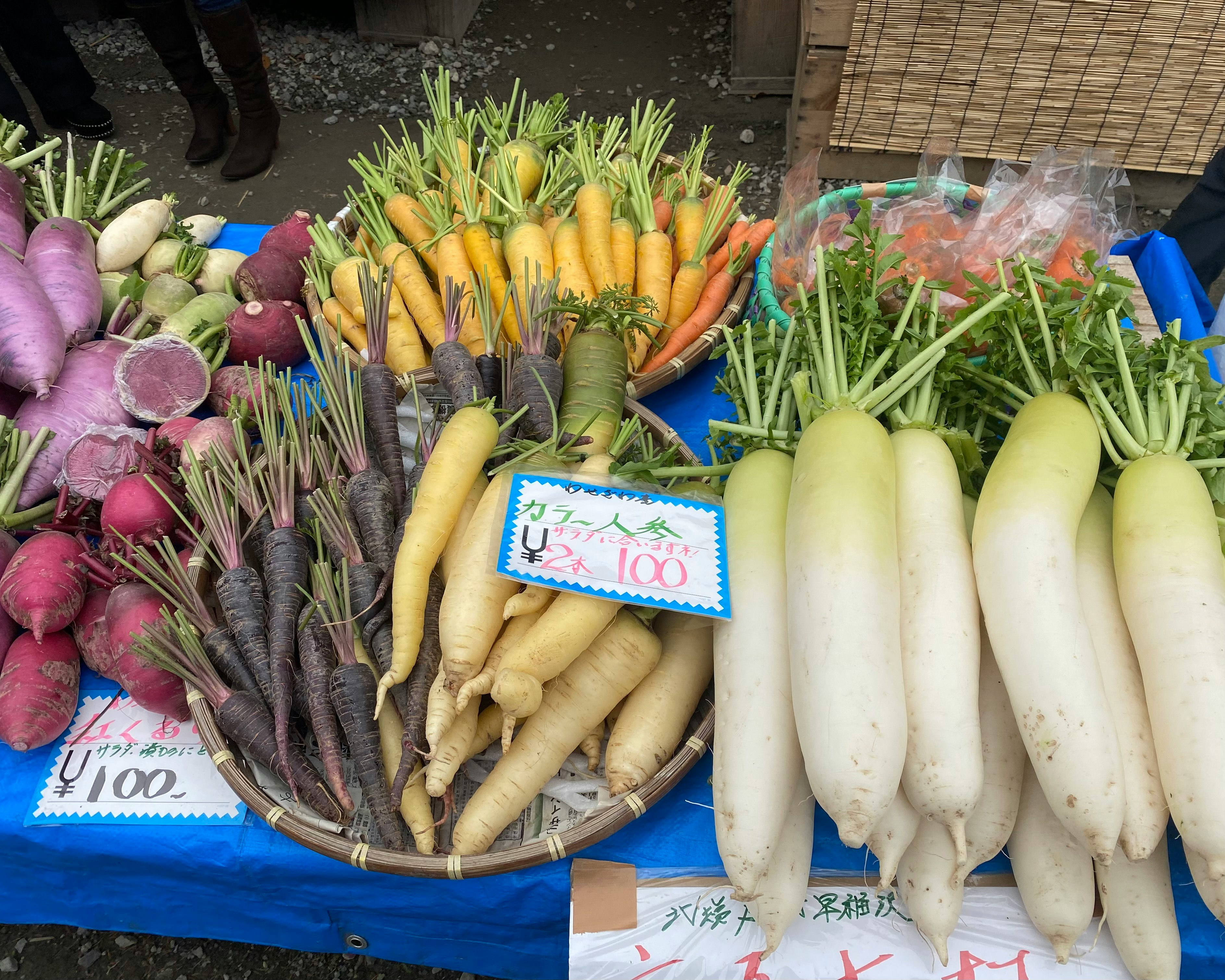 新鮮な野菜が並ぶ青い台の市場の陳列