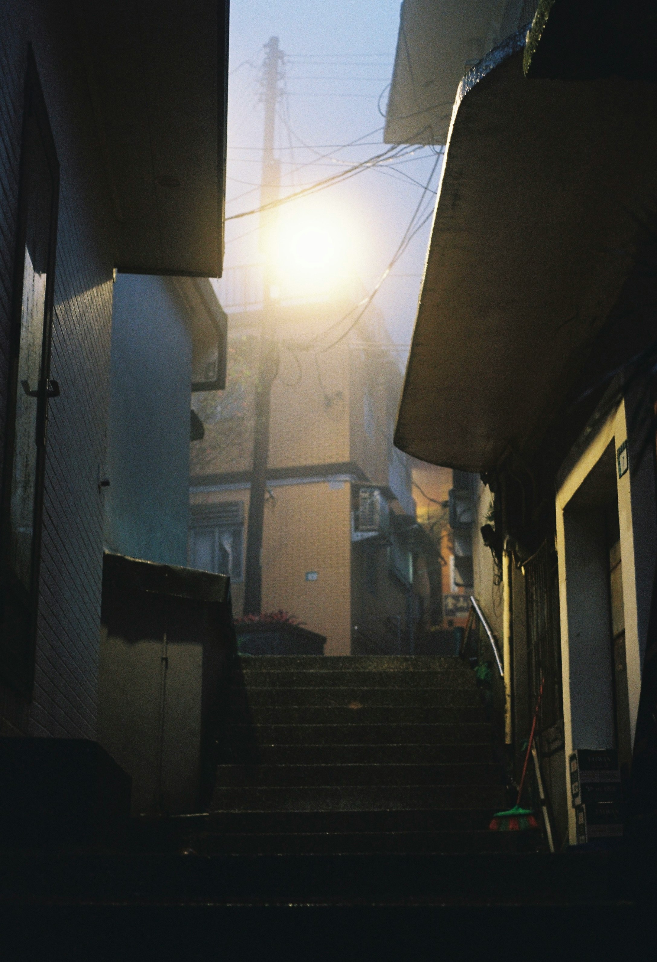 alley stairs and buildings receding into a sunset glow